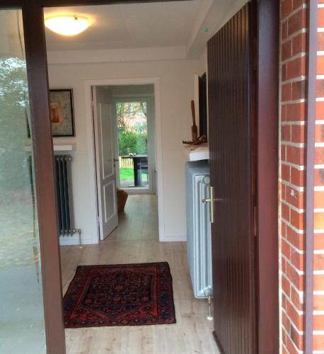 a hallway with a door leading into a living room at Ferienhaus an der Buche "Gartenblick" in Neue Tiefe Fehmarn