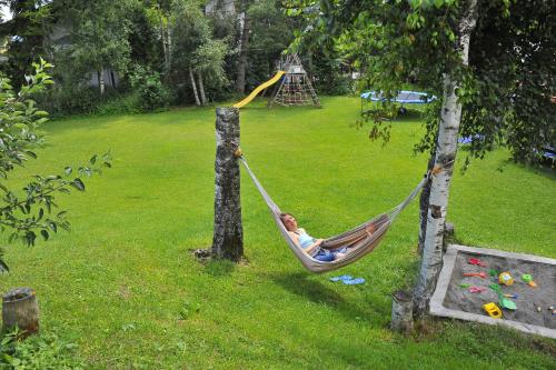 a child sitting in a hammock in a yard at Schmiedhof in Seefeld in Tirol