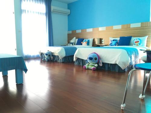 a bedroom with two beds with stuffed animals on the floor at Jing Xiang Hua Nong B&B in Dongshan