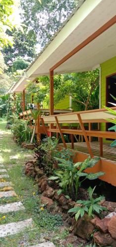 a house with a porch with wooden benches at GREEN LAND Resort in Ban Bang Bao