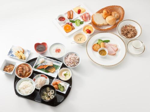 a table with plates of food and bowls of food at ART HOTEL Kashima Central in Kamisu