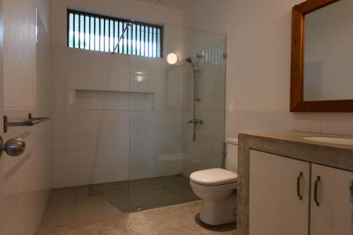 a bathroom with a toilet and a shower and a sink at Flower Road Villa in Colombo