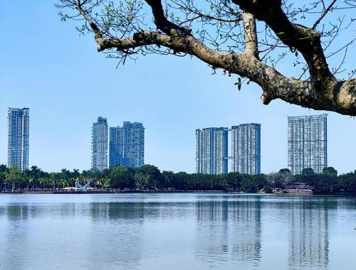 a view of a lake with tall buildings in the background at Củi Homestay Oasis Ecopark in Kim Quan