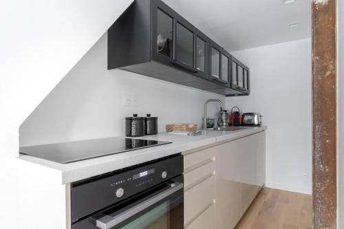 - une cuisine équipée d'un four avec plaques de cuisson en noir et blanc dans l'établissement Invalides Palais Bourbon Luxueux Appartement 4P, à Paris