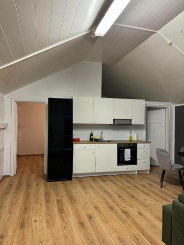 a kitchen with white cabinets and a black refrigerator at Vík Inn in Vík