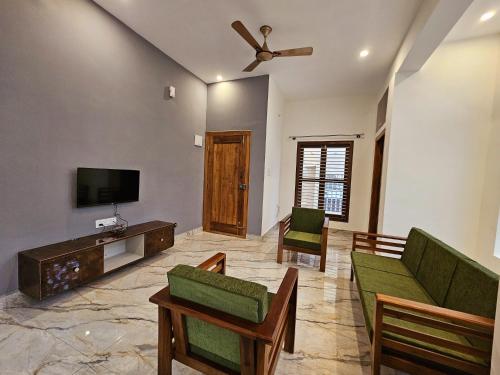 a living room with a couch and a tv at Bricknest hillview in Mysore