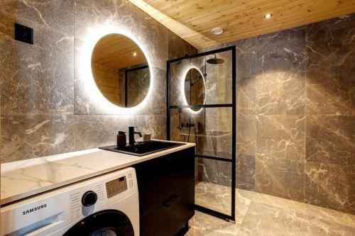 ein Badezimmer mit Waschmaschine und Waschbecken in der Unterkunft Saunamäki - Frida in Salo