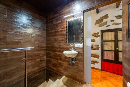 a bathroom with a sink and wooden walls at Picachico in Laroya