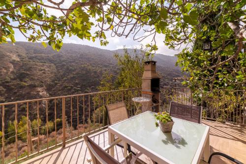 a table and chairs on a balcony with a view at Picachico in Laroya
