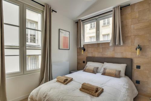 une chambre avec un lit avec deux serviettes dessus dans l'établissement 141 Suite Klein - Superbe Appartement à Paris., à Paris