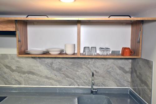 a shelf above a sink with dishes on it at Central location LOFT Apartment in Avcılar