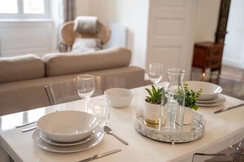 une table avec des assiettes et des verres à vin dessus dans l'établissement CHIC ANDREOSSY-COSY-AUTHENTIQUE-WI-Fi-Vélo, à Castelnaudary
