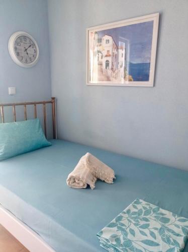 a bedroom with a bed with a clock on the wall at Villa Sophie in Orfánion