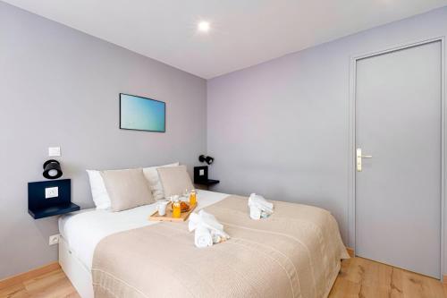 - une chambre avec deux chats blancs assis sur un lit dans l'établissement 388 Suite Trousseau - Superbe Appartement à Paris, à Paris