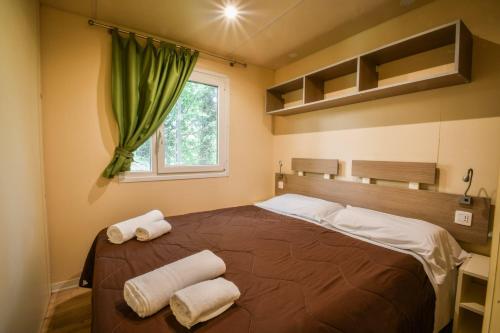a bedroom with a large bed with towels on it at hu Altomincio Village in Valeggio sul Mincio