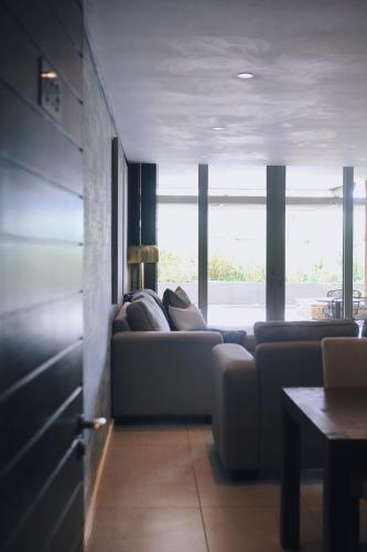a living room with a couch and a large window at Dolce vita luxurious apartment in Umhlanga