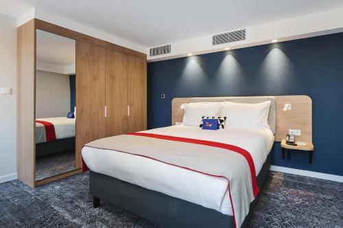 a bedroom with a large bed and a blue wall at Holiday Inn Express Lublin by IHG in Lublin