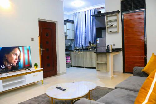 un soggiorno con un divano e una TV di FirstChoice apartments Kampala a Kampala
