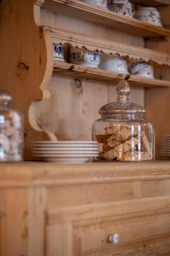 a glass jar on top of a wooden cabinet at Alpina Lech - Geborgen in den Bergen in Lech am Arlberg