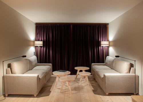 a living room with two couches and a table at Alpina Lech - Geborgen in den Bergen in Lech am Arlberg