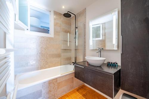 une salle de bain avec un lavabo et une baignoire et un lavabo dans l'établissement Superbe 3p vue mer avec parking, à Nice