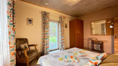 a bedroom with a bed and a chair and a window at Lauku iela 25 in Jūrmala