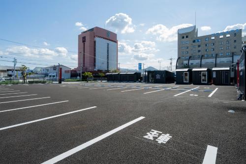 an empty parking lot with a building in the background at HOTEL R9 The Yard Sakaide in Sakaide