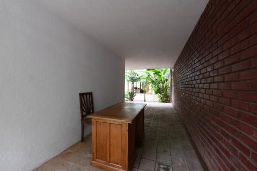 a room with a wooden desk and a brick wall at Flower Road Villa in Colombo