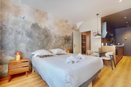 une chambre avec un grand lit avec un tableau au mur dans l'établissement Studio Moderne en plein coeur de la Vieille Ville d'Annecy, à Annecy