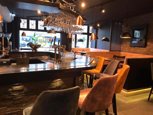 een restaurant met een tafel en stoelen en een bar bij Boutique Hotel Noordeinde in Rijnsburg