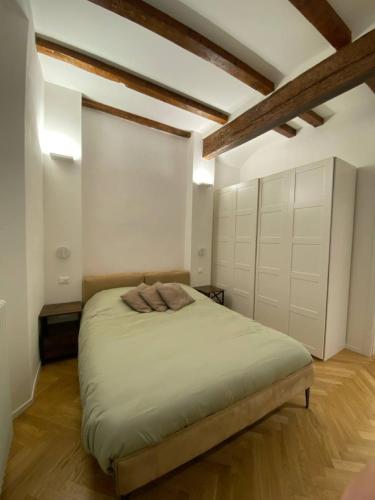 a bedroom with a bed with white walls and wooden beams at La Nicchia in Bologna