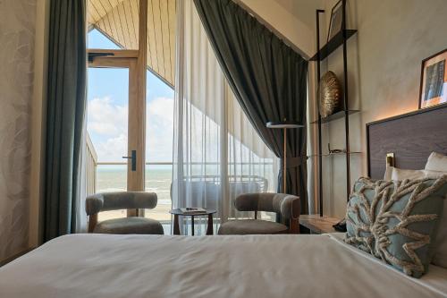a hotel room with a bed and a large window at Boutique Hotel Blendin Bloemendaal aan Zee in Bloemendaal Aan Zee