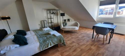 a bedroom with a bed and a desk and a chair at Bed&Beach La Primavera in De Koog