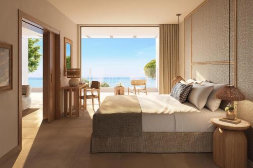 a bedroom with a bed and a view of the ocean at Ikos Olivia in Gerakini