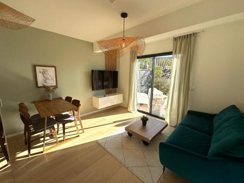 a living room with a green couch and a table at Les Loges de la Mer - Pérols in Pérols