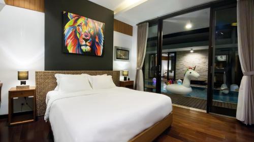a bedroom with a white bed and a room with a deer at Villa Nusa Dua by Opus Hospitality in Nusa Dua