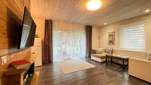 a living room with a television and a couch at Lauku iela 25 in Jūrmala