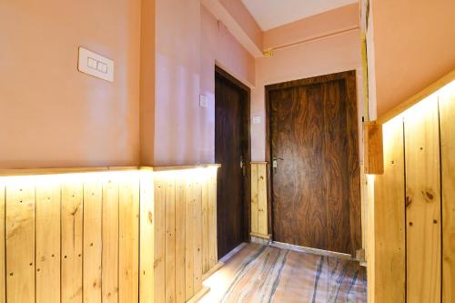an empty room with a wooden door and wooden floors at FabHotel The Golden Orchid in Ālīpur