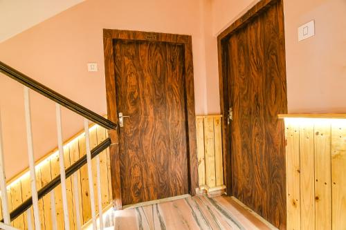 an empty room with a wooden door and stairs at FabHotel The Golden Orchid in Ālīpur