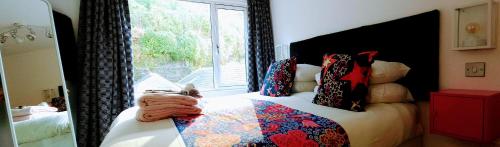 a bedroom with a bed with a large window at Boat House Super Suites in Rothesay
