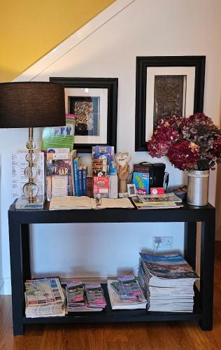 a book shelf with books and magazines on it at Boat House Super Suites in Rothesay