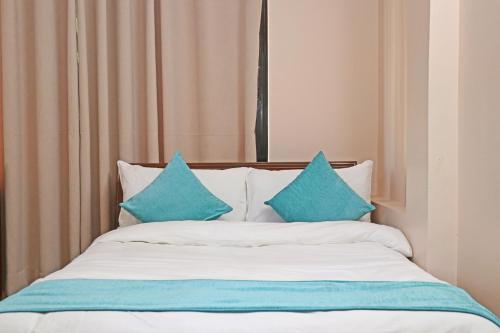 a bed with blue pillows on top of it at Hotel Resunga Arjun in Kathmandu