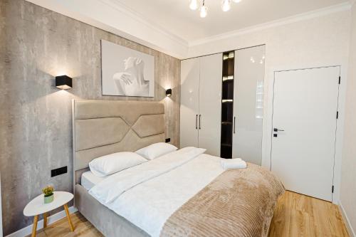 a bedroom with a large bed and a table at Luxury Oasis Flat in Chişinău