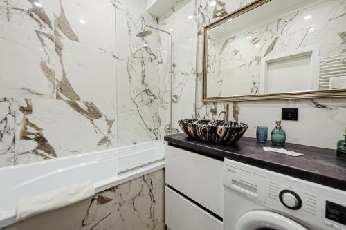 a bathroom with a tub and a sink and a washing machine at Luxury Oasis Flat in Chişinău