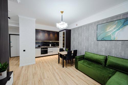 a living room with a green couch and a table at Luxury Oasis Flat in Chişinău