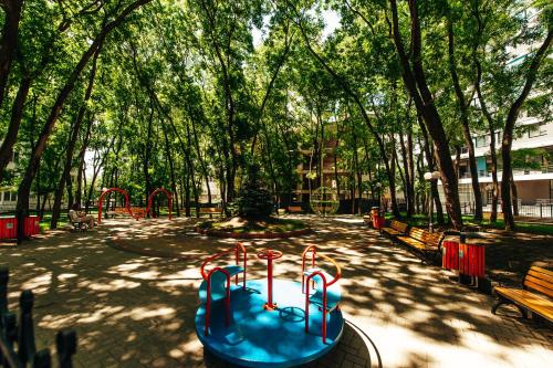 a playground in a park with trees and benches at Luxury Oasis Flat in Chişinău