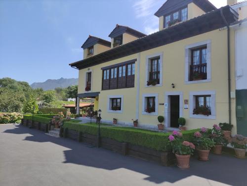 a large white house with plants in front of it at Casa de Aldea El Frade in Ribadesella