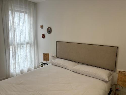 a bedroom with a white bed with a large window at Vivienda turística El Caminante con garaje in Soria