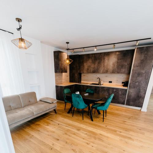 a living room with a couch and a table and chairs at Evo Residence Taietura Turcului in Cluj-Napoca