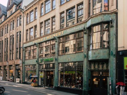 un bâtiment dans une rue de la ville avec un magasin dans l'établissement Luga Homes - Nikolaikirche, à Leipzig